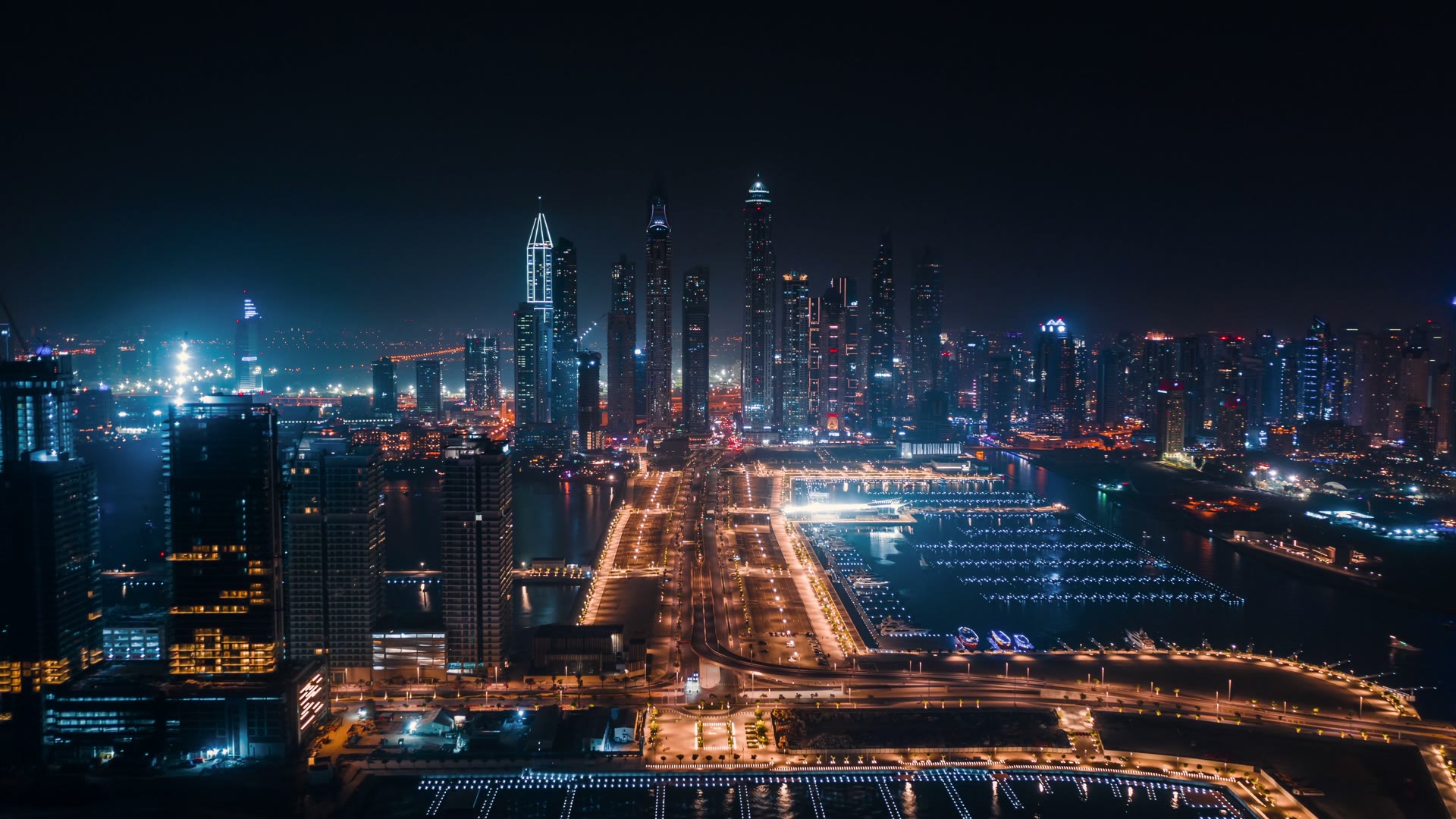 Aerial view of Dubai Marina at night — illuminated towers along the marina